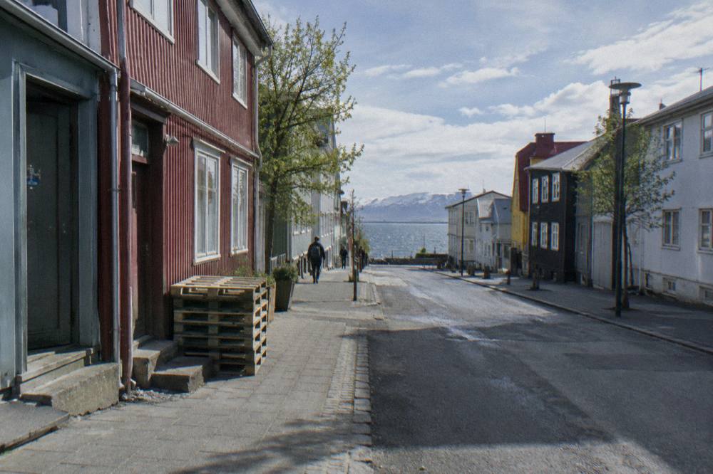 Laugavegur street scene with shopfronts and low-rise buildings under a bright sky